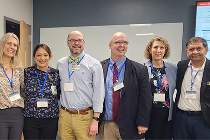 A group of medical professionals taking a photo in a classroom