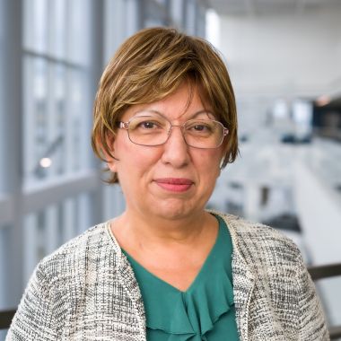 Headshot of Emily Melikman woman with short brown hair and glasses